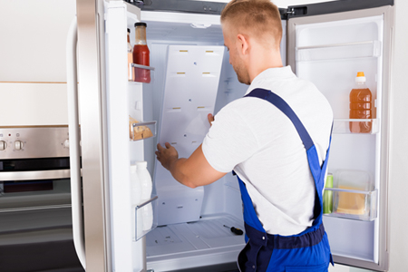 Repair man fixing fridge